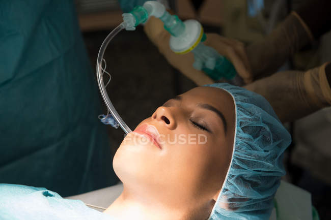 Gros plan du patient avec masque à oxygène en salle d'opération — Photo de stock