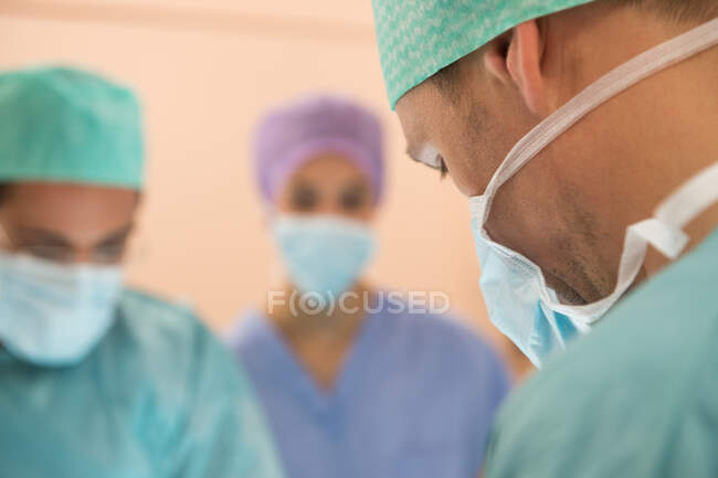 Equipo médico realizando una operación en un quirófano - foto de stock
