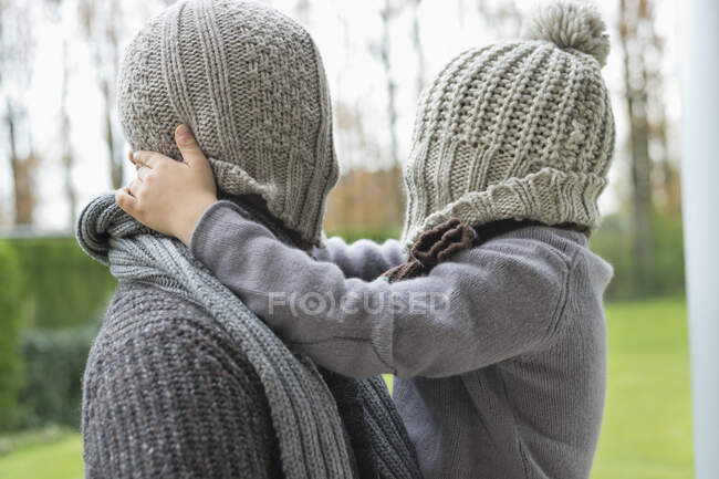 Homem e filho cobrindo seus rostos com chapéus — Fotografia de Stock