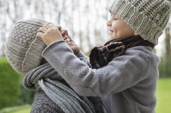 Garçon jouant avec la casquette de son père — Photo de stock