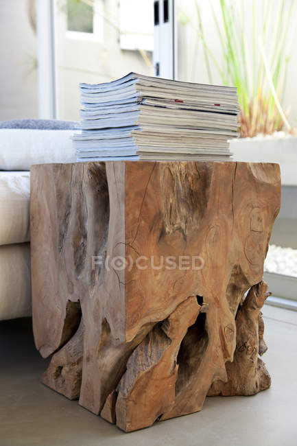 Pilha de revistas na mesa projetada feita de toco de árvore — Fotografia de Stock