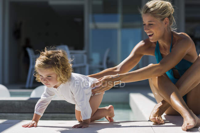Молода жінка грає зі своєю дочкою на курорті — стокове фото