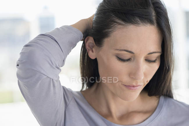 Крупним планом сумна брюнетка жінка торкається волосся — стокове фото