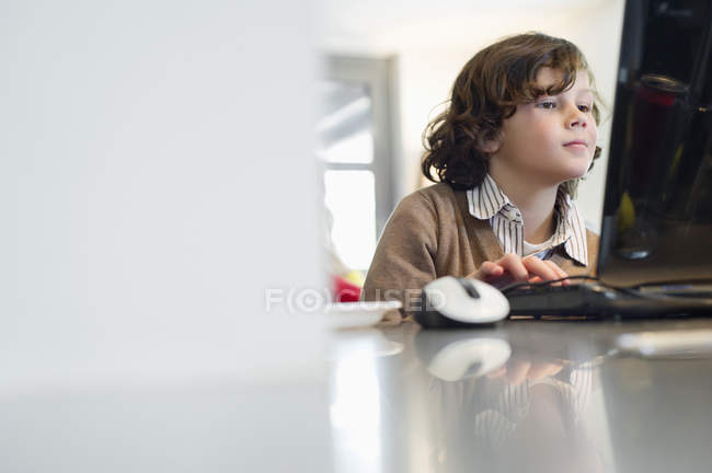 Menino usando laptop na mesa em casa — Fotografia de Stock