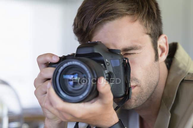 Крупним планом молодий чоловік фотографує з камерою — стокове фото