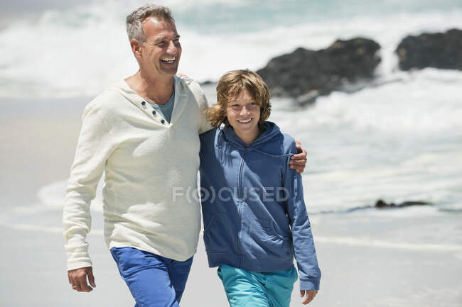 Чоловік ходить зі своїм онуком на пляжі — стокове фото