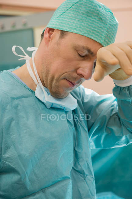 Chirurgien masculin fatigué dans la salle d'opération après l'opération — Photo de stock