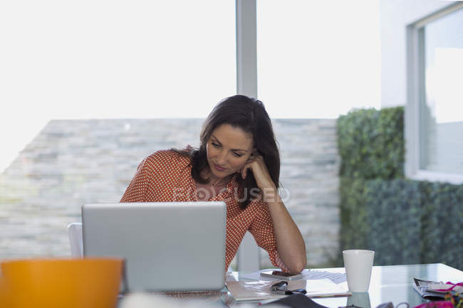 Concentrated fashion designer working on laptop in office — Stock Photo