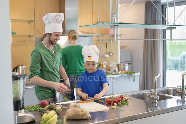 Happy family cooking together in kitchen — Stock Photo