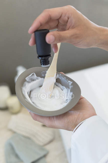 Primer plano de las manos femeninas preparando tinte para el cabello - foto de stock