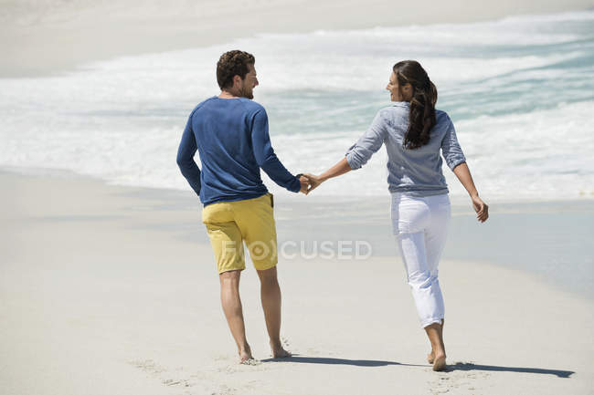 Пара прогулок по песчаному пляжу — стоковое фото