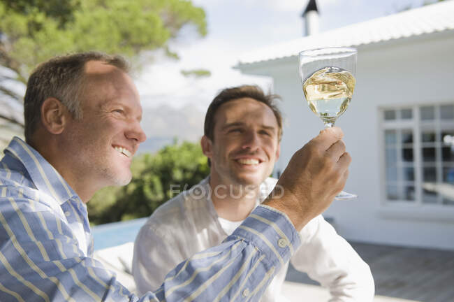 Двоє друзів дивляться на келих для вина — стокове фото