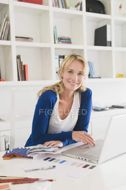Portrait of smiling businesswoman choosing color swatches — Stock Photo