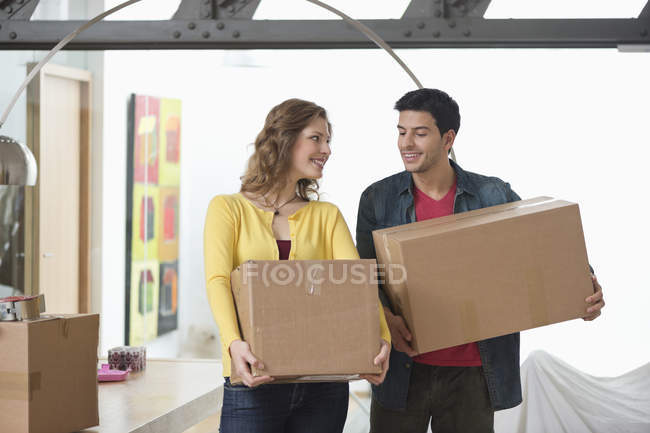 Пара, що носить картонні коробки і посміхається — стокове фото