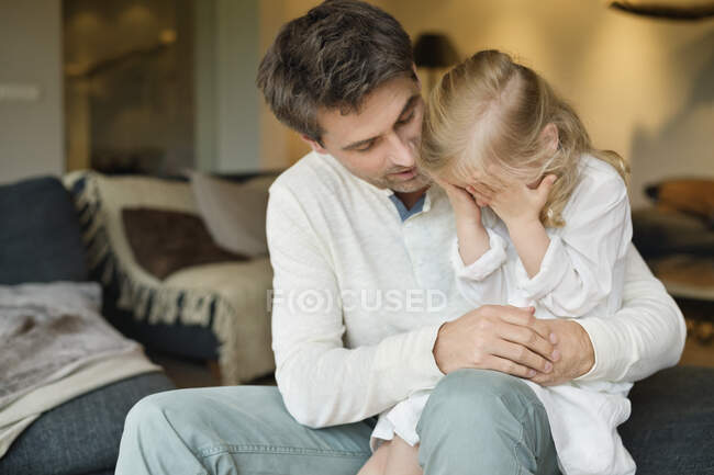 Uomo che tiene la sua graziosa figlia che copre gli occhi con le mani — Foto stock