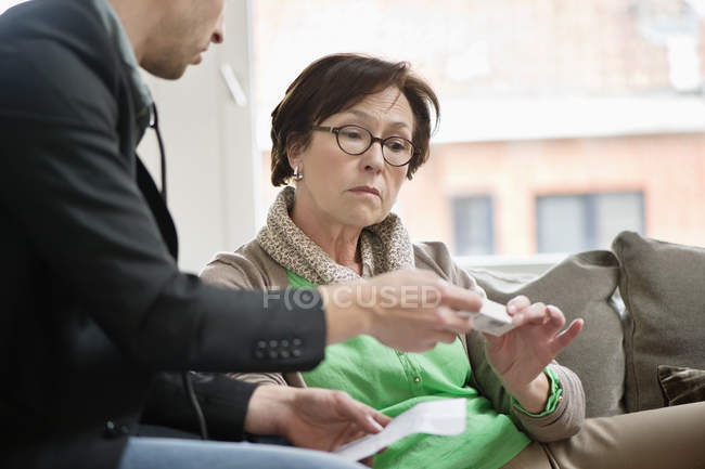 Male doctor giving medicine to female patient — Stock Photo