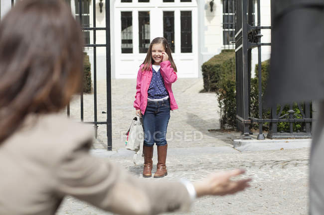 Жінка дає теплий прийом дочці біля шкільних воріт — стокове фото
