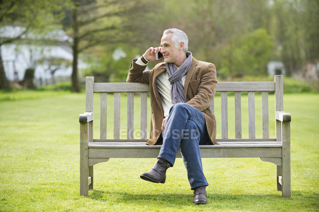 Элегантный мужчина разговаривает по мобильному телефону в парке — стоковое фото