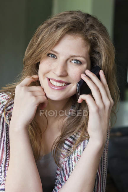 Портрет улыбающейся женщины, разговаривающей по мобильному телефону — стоковое фото