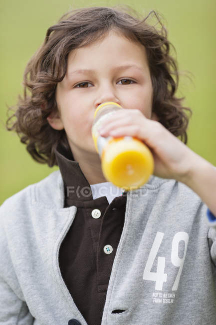 Retrato de menino bebendo suco de garrafa ao ar livre — Fotografia de Stock