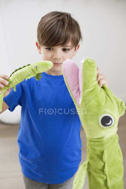 Портрет маленького хлопчика, який грає з тваринними іграшками — стокове фото