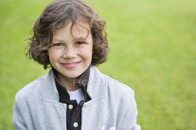 Портрет хлопчика, який посміхається в зеленому полі — стокове фото