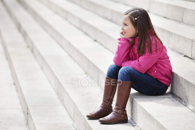Petite fille assise sur les escaliers à l'extérieur — Photo de stock
