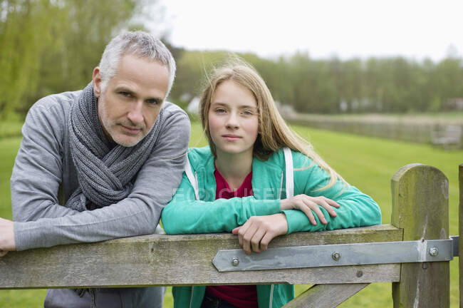 Hombre con su hija en una granja - foto de stock