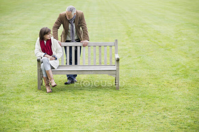 Homme assis avec sa fille sur un banc dans un parc — Photo de stock