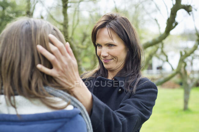 Woman pamper her daughter in a park — Stock Photo