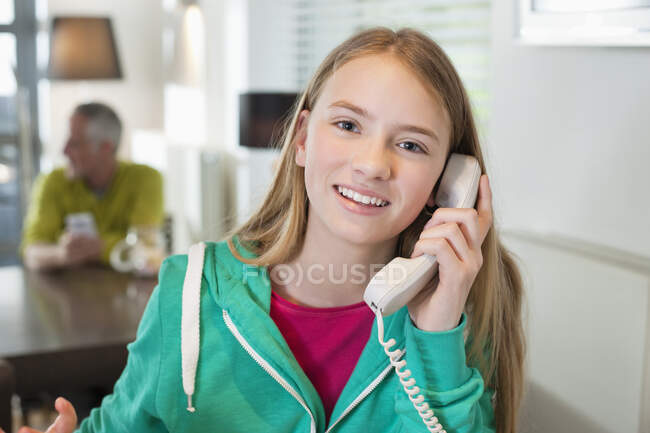 Retrato de uma menina falando em um telefone e sorrindo — Fotografia de Stock