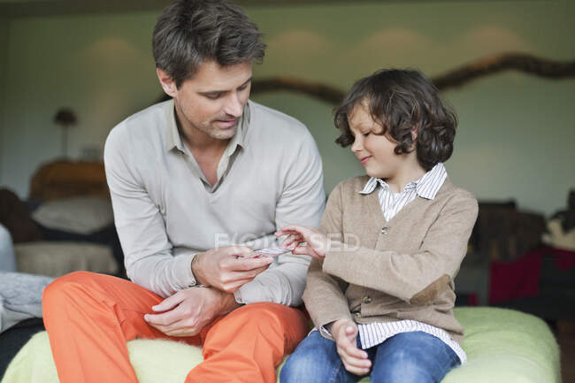 Мужчина играет в карты со своим сыном — стоковое фото