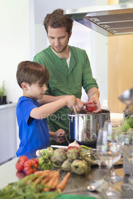 Хлопчик допомагає батькові на кухні — стокове фото
