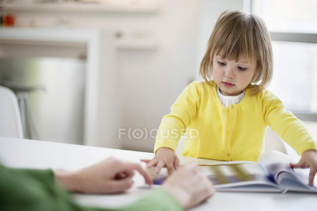 Nahaufnahme der Mutter, die ihre kleine Tochter zu Hause unterrichtet — Stockfoto