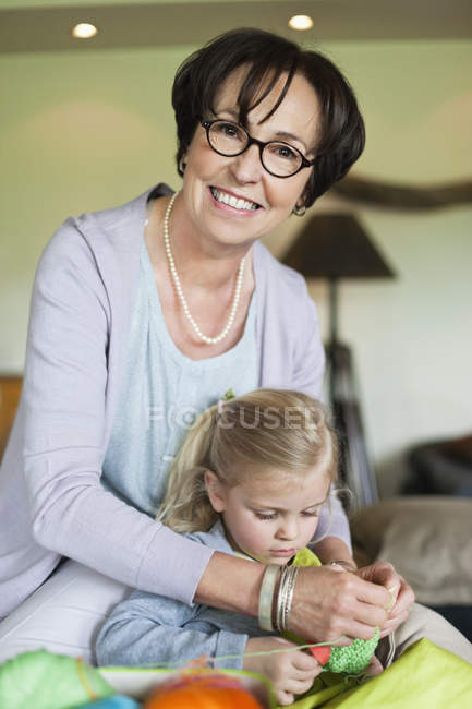 Little girl learning knitting with grandmother — Stock Photo