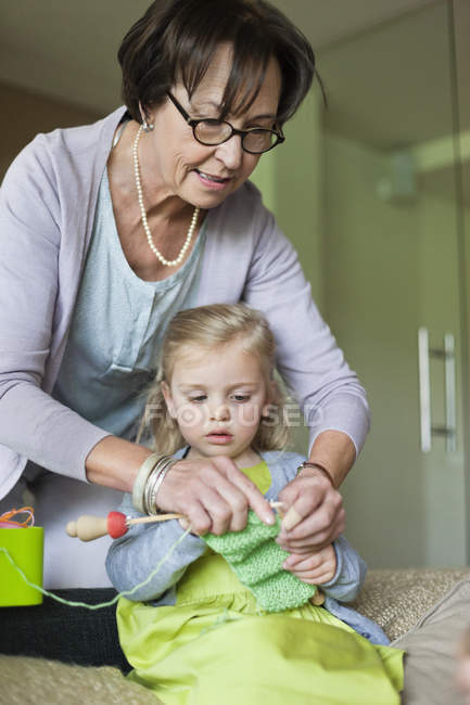 Little girl learning knitting with grandmother — Stock Photo