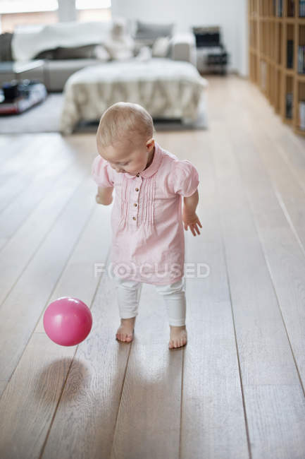 Allegra bambina che gioca con la palla a casa — Foto stock