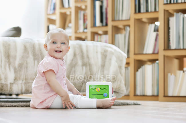 Bébé fille jouer avec bloc musical jouet sur le sol à la maison — Photo de stock