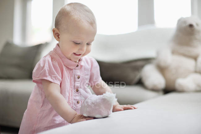Улыбающаяся девочка, играющая с игрушкой дома — стоковое фото