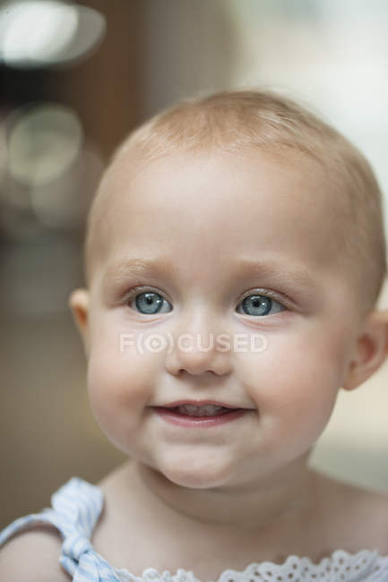 Primer plano de la niña con los ojos azules sonriendo - foto de stock