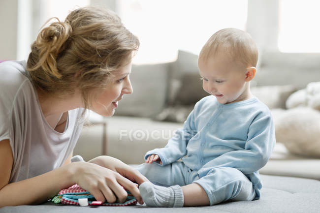 Femme jouant avec la fille de bébé gaie à la maison — Photo de stock