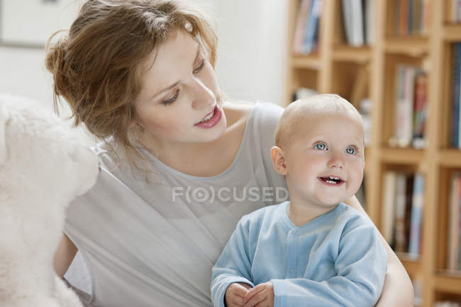 Young woman playing with smiling baby daughter — Stock Photo