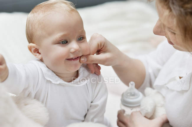 Закри жінка грає з посмішкою і немовляти дочки — стокове фото