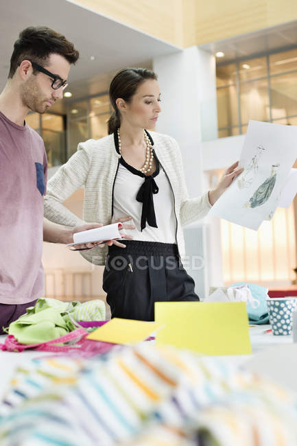 Diseñadores de moda trabajando en oficina con bocetos - foto de stock