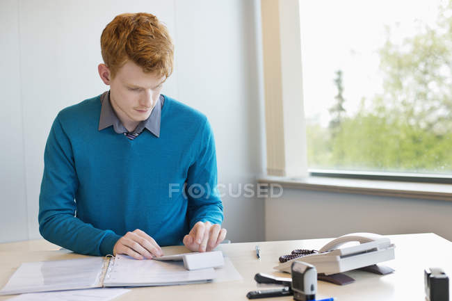 Jeune homme d'affaires de gingembre travaillant au bureau — Photo de stock