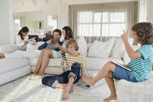 Familia usando aparatos electrónicos - foto de stock