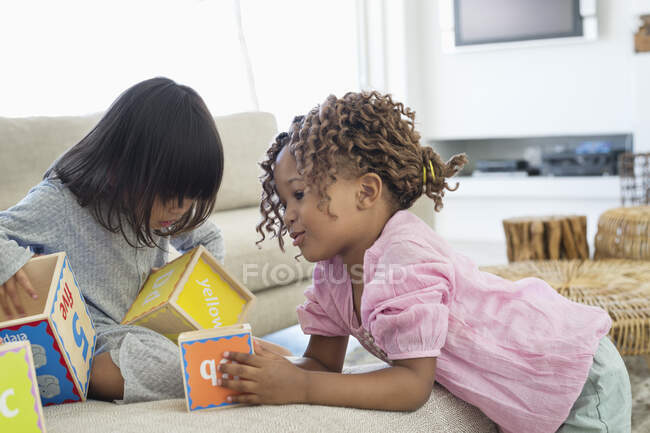 Dos chicas jugando con bloques numéricos - foto de stock