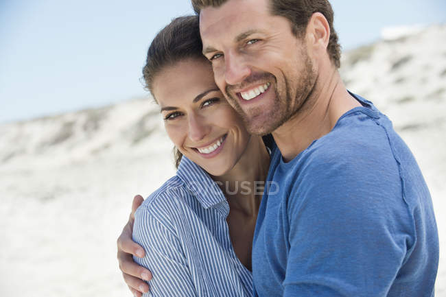 Портрет счастливой романтической пары, обнимающейся на пляже — стоковое фото