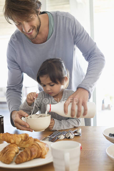 Man giving milk to his daughter — Stock Photo