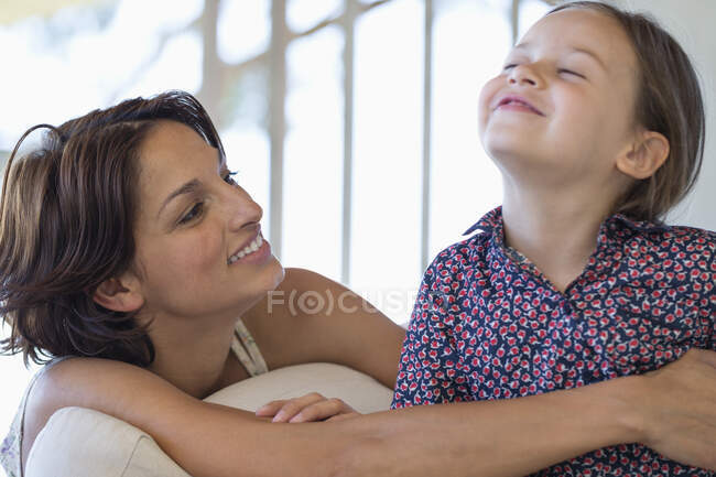 Женщина улыбается с дочерью дома — стоковое фото